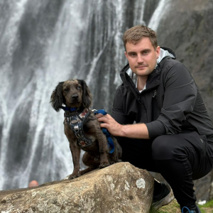 matthew robinson with dog in front of waterfall